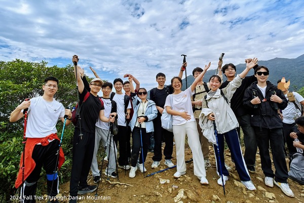 Lab members gathered on a ridge with mountain scenery behind them
