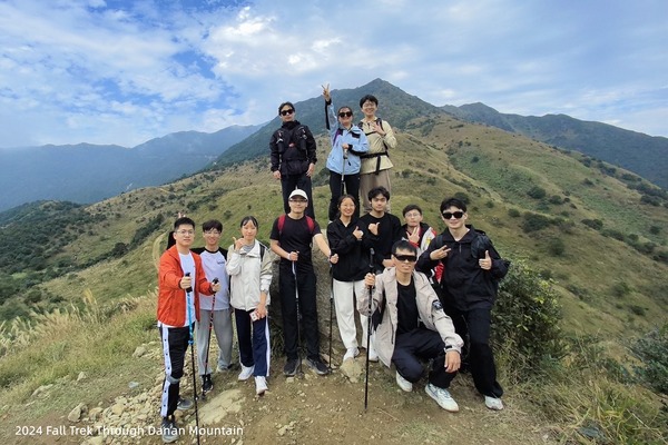 Lab members walking single file along a green mountain trail