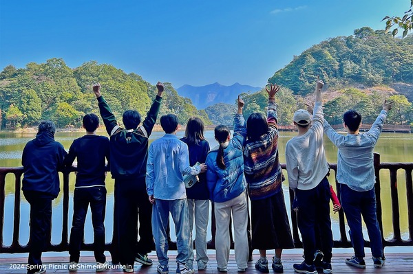 Lab members seen from behind while looking across a mountain lake
