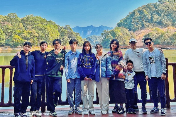 Lab members posing together beside a lake during a spring picnic