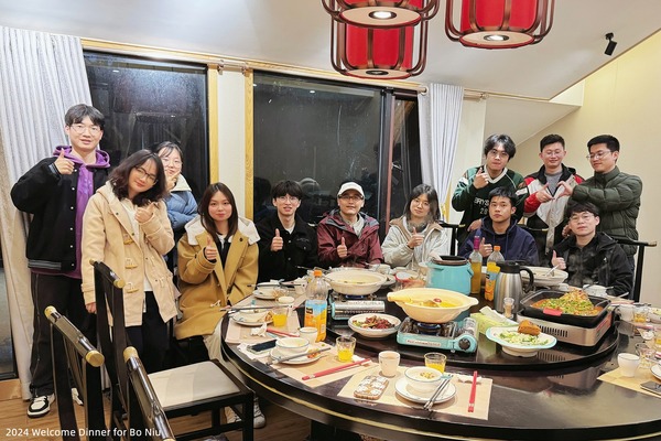 Lab members seated together around a restaurant table at a welcome dinner